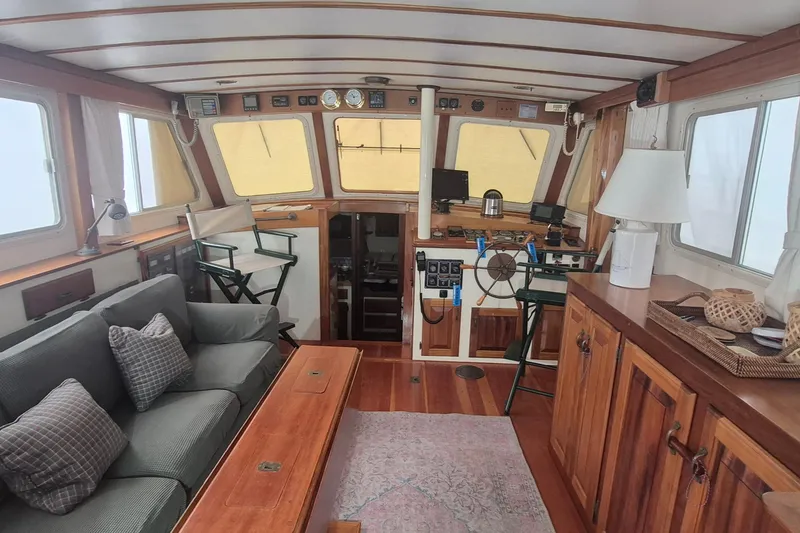 Slide: The Image of Interior of 1988 Custom Holland Wesmac-Foley Flybridge Cruiser with cozy seating and wooden accents. - 2
