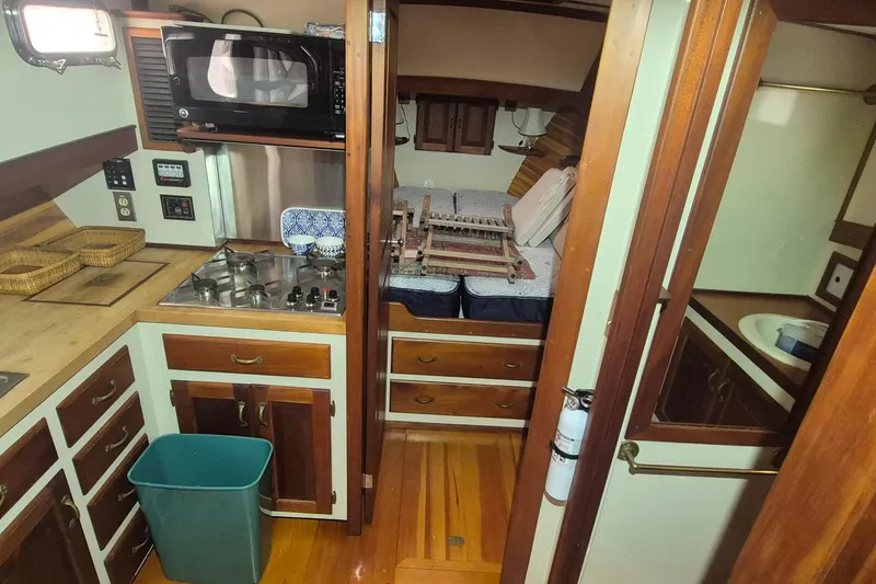 Slide: The Image of 1988 Custom Holland Wesmac-Foley Flybridge Cruiser interior with kitchen and sleeping area. - 25