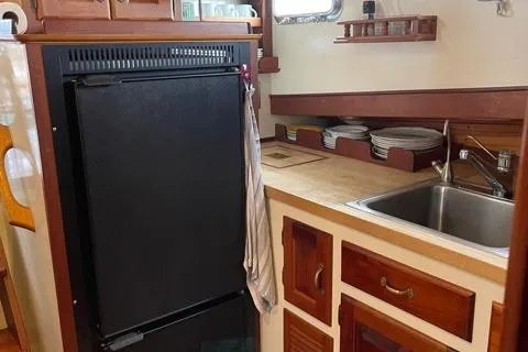 Slide: The Image of 1988 Holland Wesmac-Foley Flybridge Cruiser kitchen with sink and refrigerator. - 28