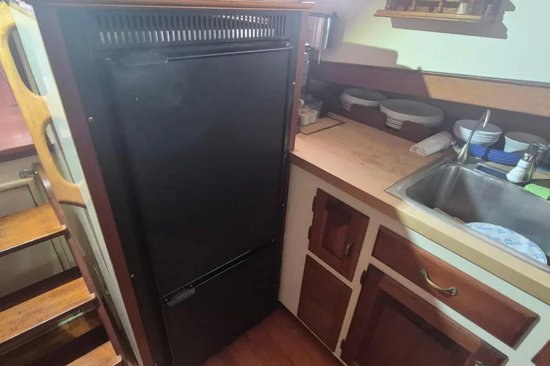 Slide: The Image of Compact kitchen area on 1988 Holland Wesmac-Foley Flybridge Cruiser with fridge and sink. - 34