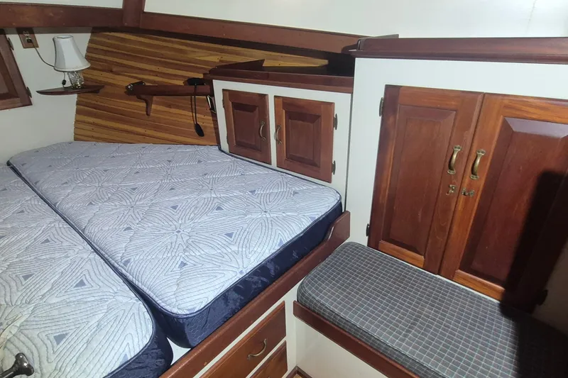 Slide: The Image of Cozy cabin interior of 1988 Holland Wesmac-Foley Flybridge Cruiser with wooden cabinets and bed. - 37