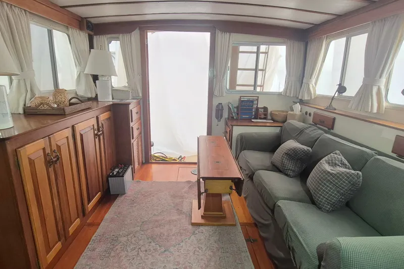 Slide: The Image of Interior of 1988 Holland Wesmac-Foley Flybridge Cruiser with cozy seating and wooden cabinetry. - 4