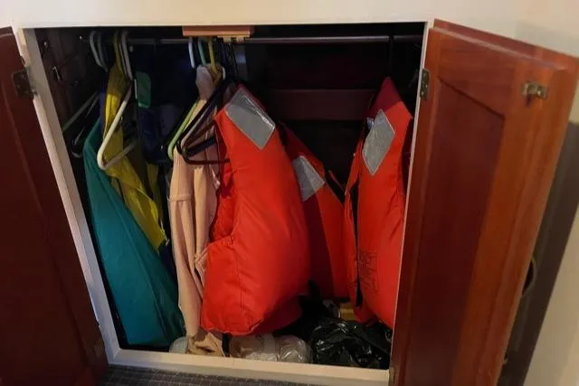 Slide: The Image of Cabinet with life jackets and clothing on a boat. - 45