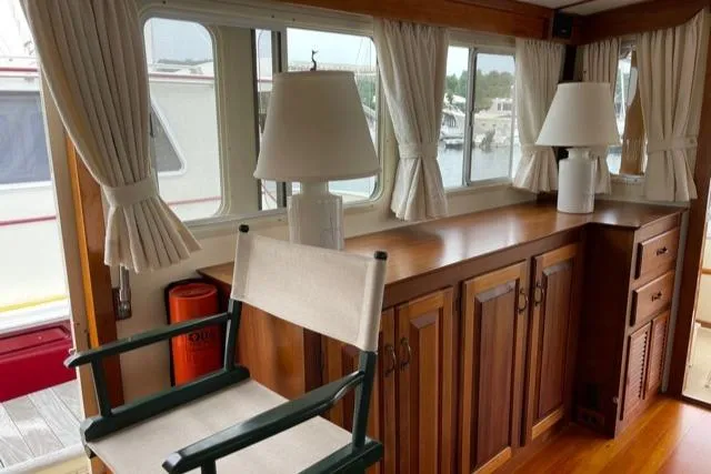 Slide: The Image of Interior of 1988 Holland Wesmac-Foley Flybridge Cruiser with wooden furniture and windows. - 7