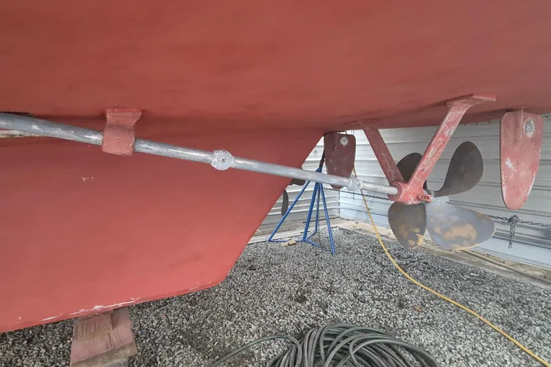 Slide: The Image of 1988 Custom Holland Wesmac-Foley Flybridge Cruiser propeller and rudder detail in dry dock. - 97