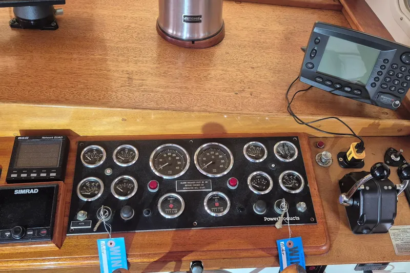 Slide: The Image of Control panel of a 1988 Custom Holland Wesmac-Foley Flybridge Cruiser with navigation instruments. - 99