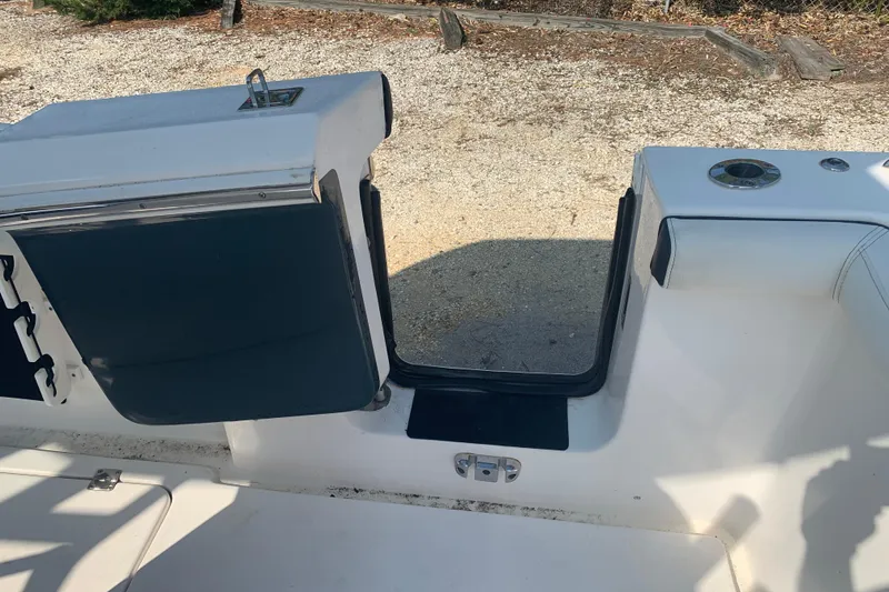 Slide: The Image of 2021 Tidewater 256 CC Adventure boat interior with open hatch and seating area. - 17