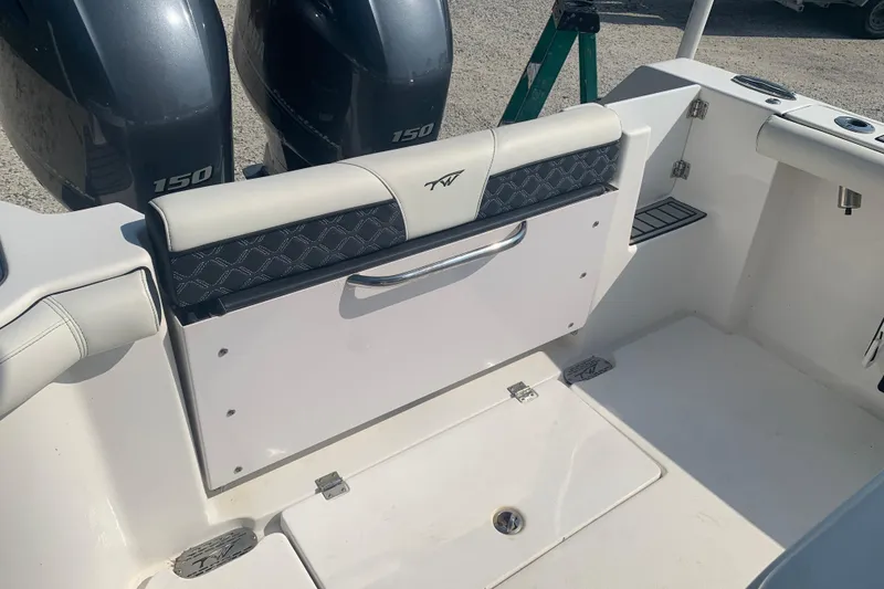 Slide: The Image of 2021 Tidewater 256 CC Adventure boat interior with dual 150 engines and seating area. - 18