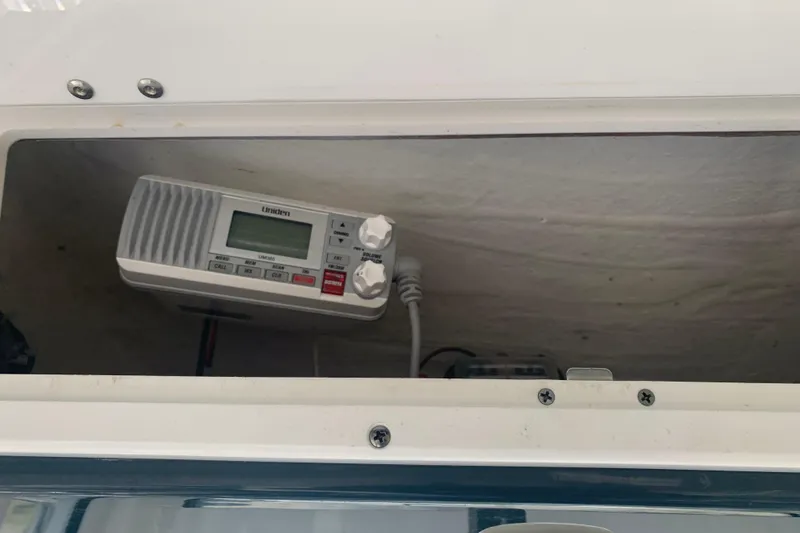 Slide: The Image of Radio equipment inside a 2021 Tidewater 256 CC Adventure boat compartment. - 33