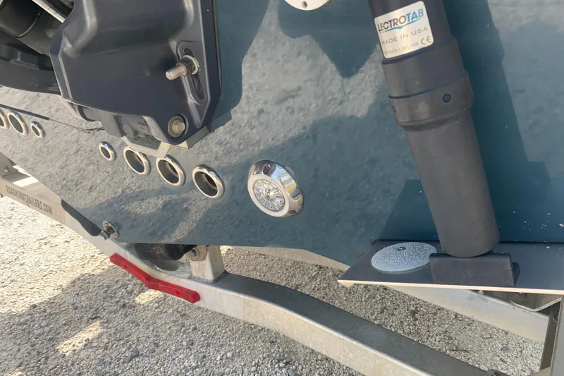 Slide: The Image of 2021 Tidewater 256 CC Adventure boat detail with trim tab and fittings. - 6