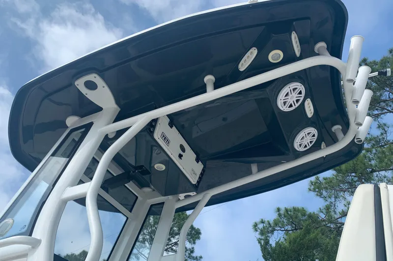 Slide: The Image of 2021 Tidewater 256 CC Adventure boat T-top with speakers and rod holders. - 7