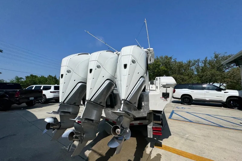 Slide: The Image of 2023 Fountain Bluewater 38 CC with triple outboard engines in a parking lot. - 10