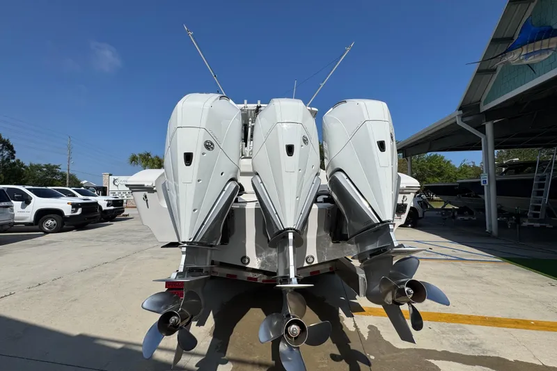 Slide: The Image of 2023 Fountain Bluewater 38 CC boat with triple outboard engines in a marina setting. - 11