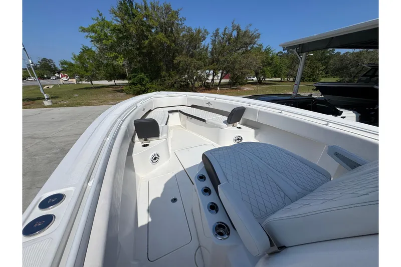 Slide: The Image of 2023 Fountain Bluewater 38 CC boat interior with cushioned seating and speakers. - 16