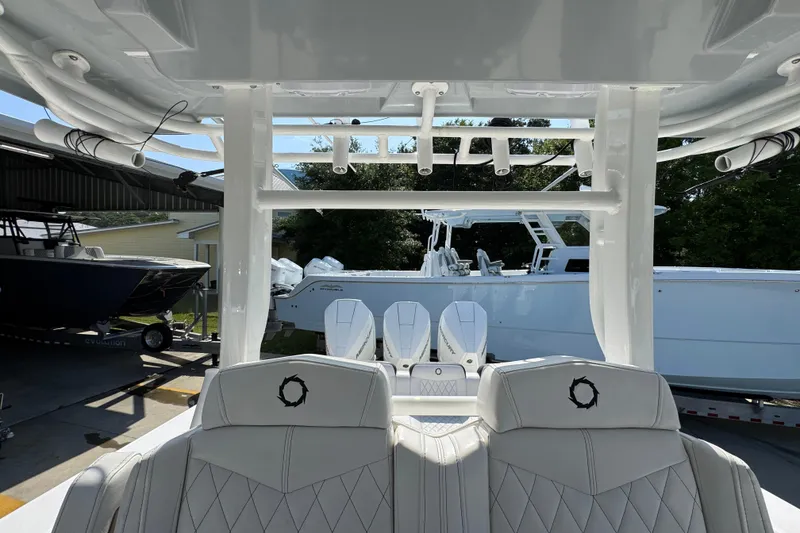 Slide: The Image of 2023 Fountain Bluewater 38 CC boat interior with white seating and rod holders. - 25