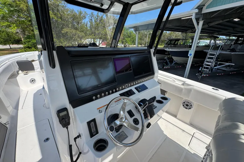 Slide: The Image of 2023 Fountain Bluewater 38 CC boat cockpit with modern navigation displays and steering wheel. - 27