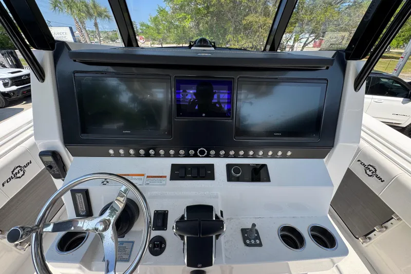 Slide: The Image of 2023 Fountain Bluewater 38 CC boat dashboard with dual screens and steering wheel. - 28