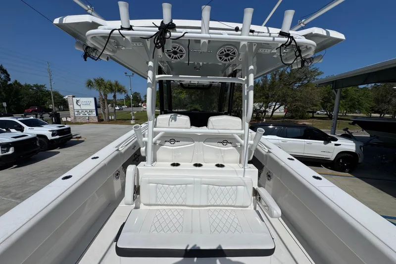 Slide: The Image of 2023 Fountain Bluewater 38 CC boat with white seating and T-top in a marina setting. - 32