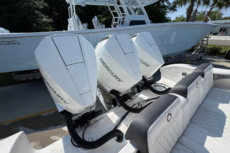 Slide: The Image of 2023 Fountain Bluewater 38 CC with triple Mercury outboard engines, docked under palm trees. - 38