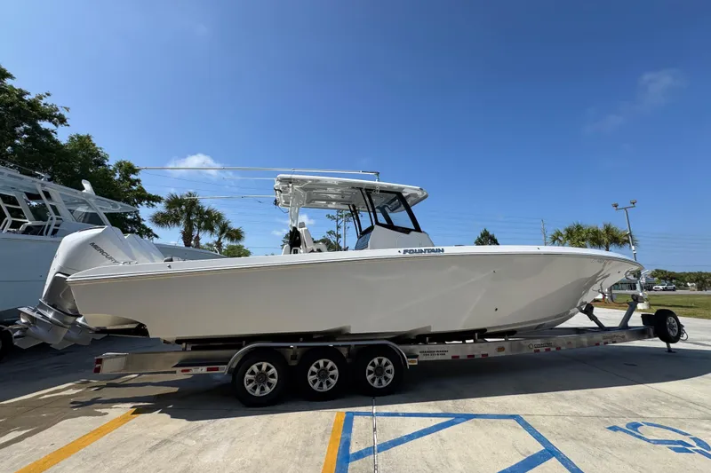 Slide: The Image of 2023 Fountain Bluewater 38 CC boat on trailer under clear blue sky. - 7