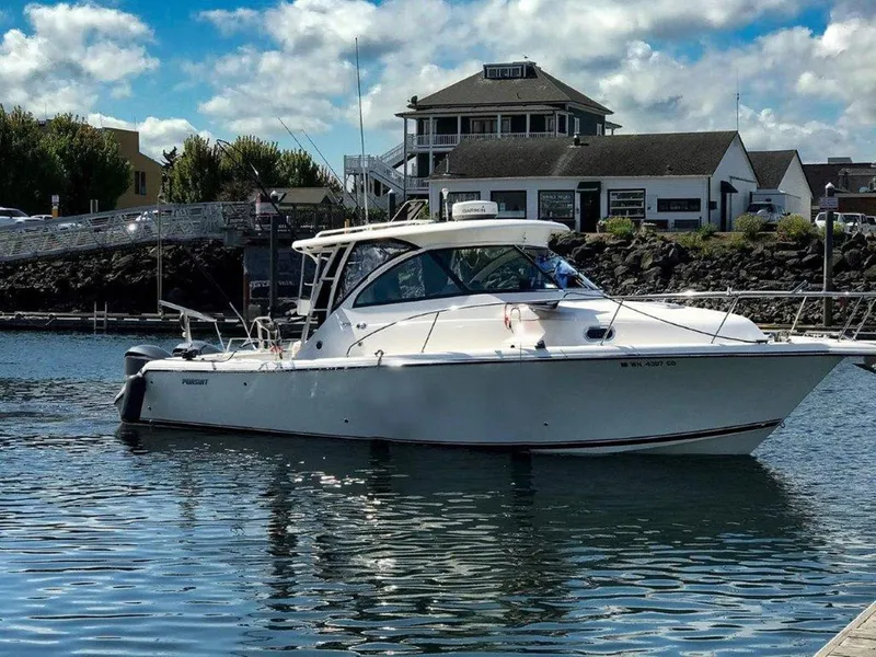 The Image of 2013 Pursuit 345 OS Offshore boat docked in a scenic harbor. - 1