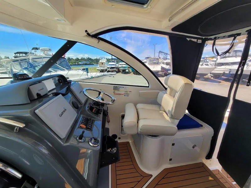 Slide: The Image of 2013 Pursuit 345 OS Offshore boat interior with helm, steering wheel, and navigation equipment. - 13