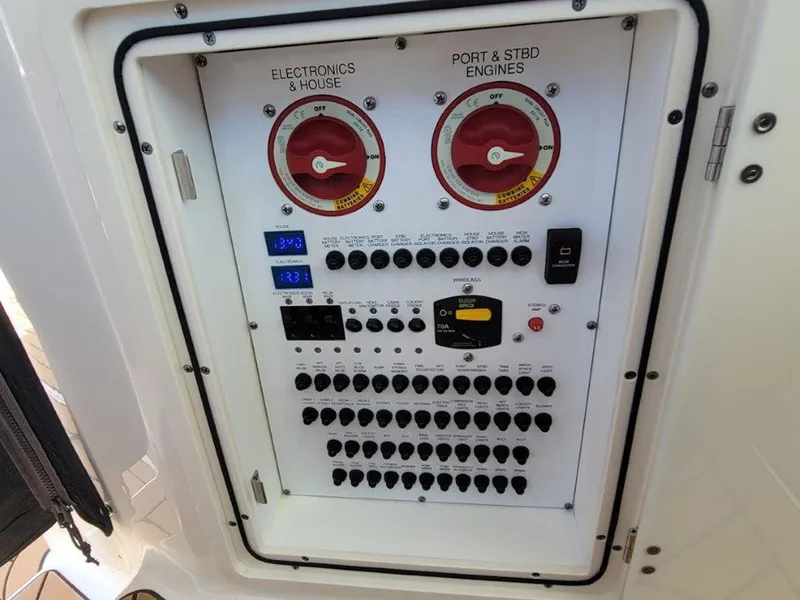 Slide: The Image of Electrical panel of a 2013 Pursuit 345 OS Offshore boat, featuring switches and gauges. - 19