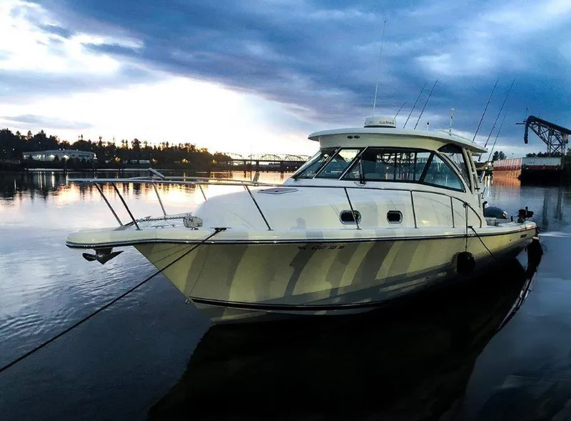 Slide: The Image of 2013 Pursuit 345 OS Offshore boat docked at sunset, reflecting on calm water. - 2