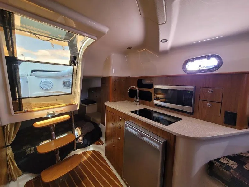 Slide: The Image of Interior of 2013 Pursuit 345 OS Offshore boat with kitchenette and wooden accents. - 25