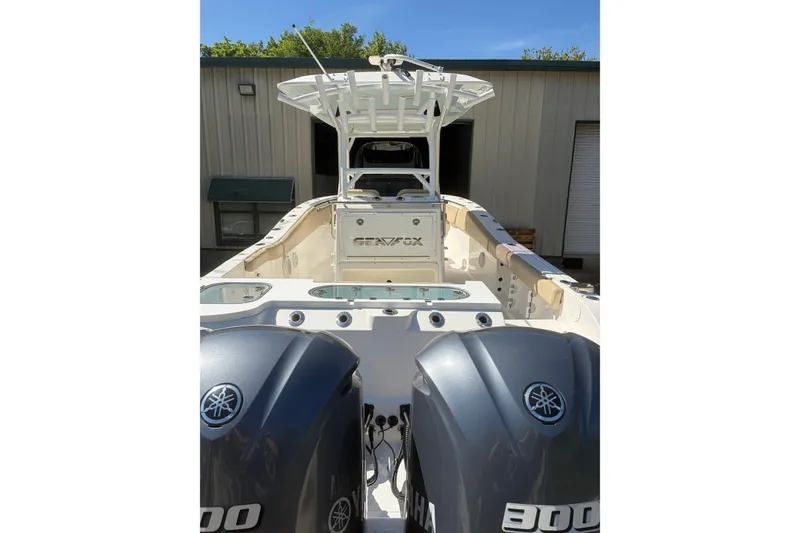 Slide: The Image of 2018 Seafox 288 Commander boat with dual Yamaha 300 engines, docked near a warehouse. - 22