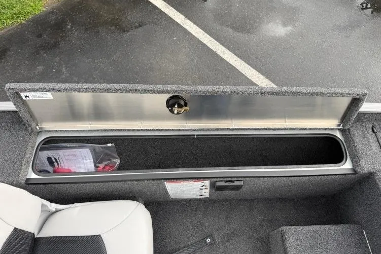 Slide: The Image of 2026 Crestliner 1600 Storm boat storage compartment open, revealing interior space. - 11