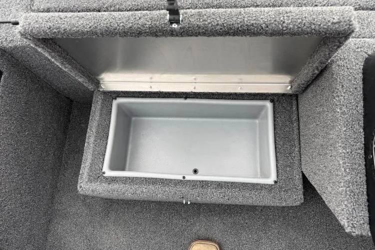 Slide: The Image of Open storage compartment in 2026 Crestliner 1600 Storm boat, featuring gray interior. - 9