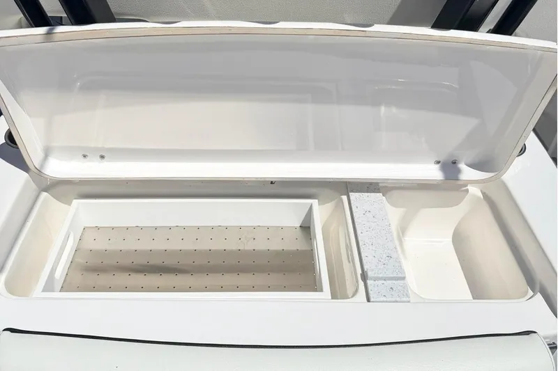 Slide: The Image of 2024 Tidewater 320 CC Adventure boat with open storage compartment and rod holders. - 15