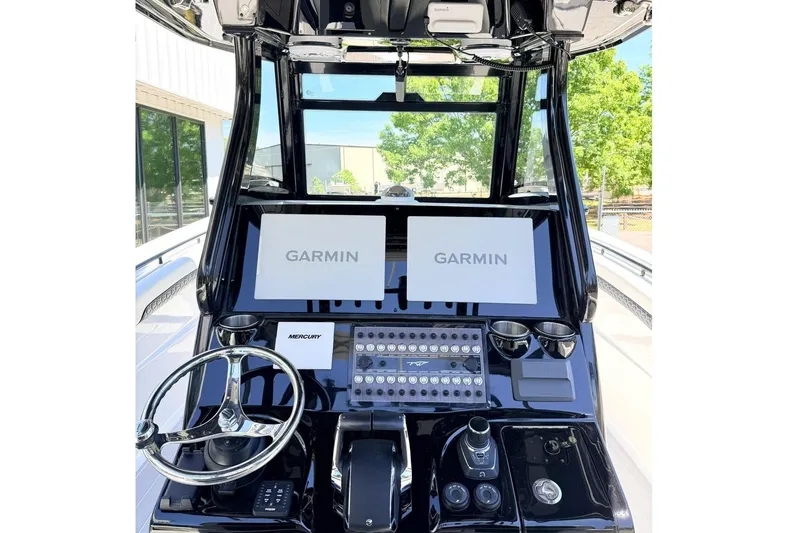 Slide: The Image of 2024 Tidewater 320 CC Adventure boat dashboard with Garmin displays and Mercury controls. - 16
