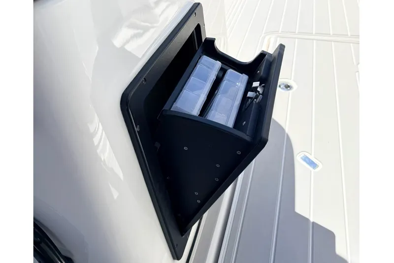 Slide: The Image of 2024 Tidewater 320 CC Adventure boat storage compartment with tackle boxes. - 23