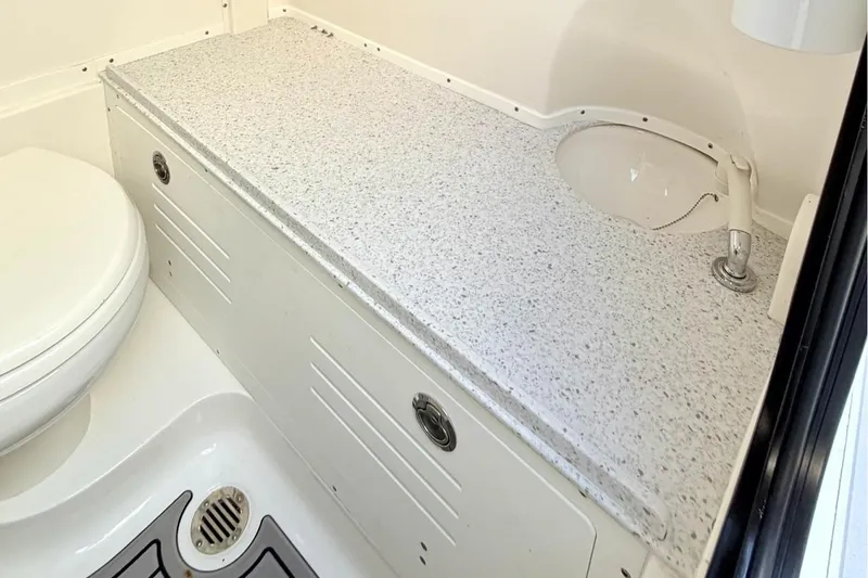 Slide: The Image of 2024 Tidewater 320 CC Adventure boat interior with control panel and compact sink. - 26