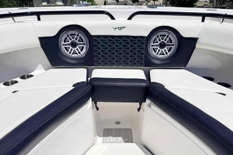 Slide: The Image of 2024 Tidewater 320 CC Adventure boat interior with cushioned seating and speakers. - 34