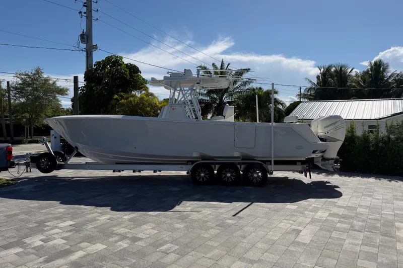 The Image of 2021 SeaVee 322Z boat on trailer, parked outdoors under clear sky. - 0