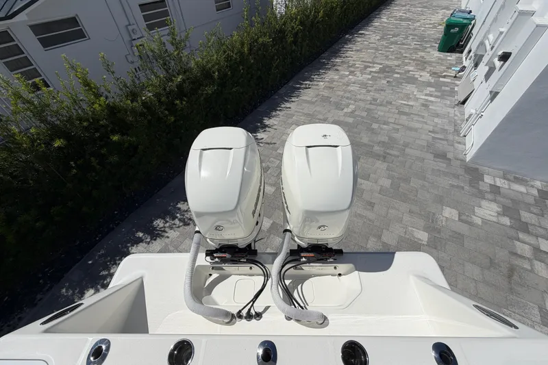Slide: The Image of Twin outboard engines on a 2021 SeaVee 322Z boat, parked on a paved driveway. - 11