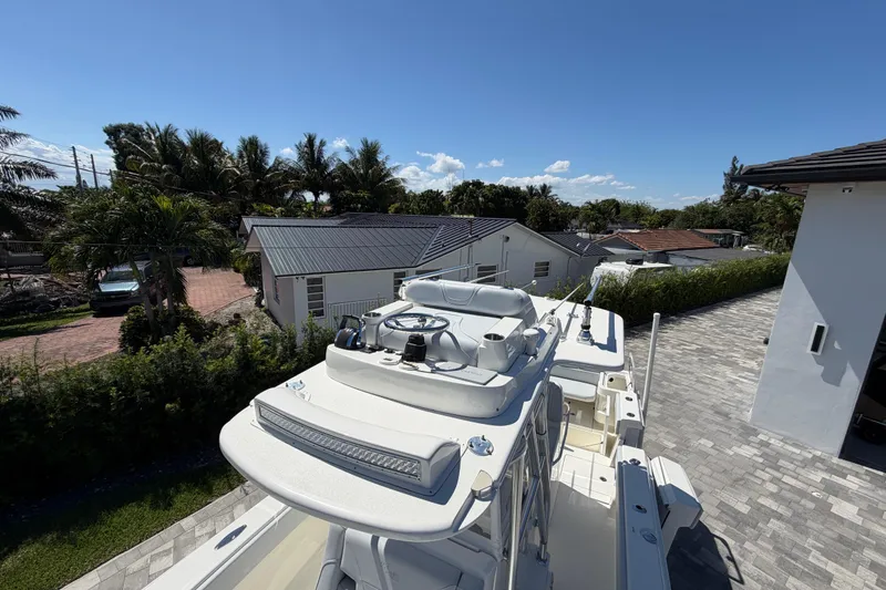 Slide: The Image of 2021 SeaVee 322Z boat parked in a driveway, surrounded by tropical trees and houses. - 20