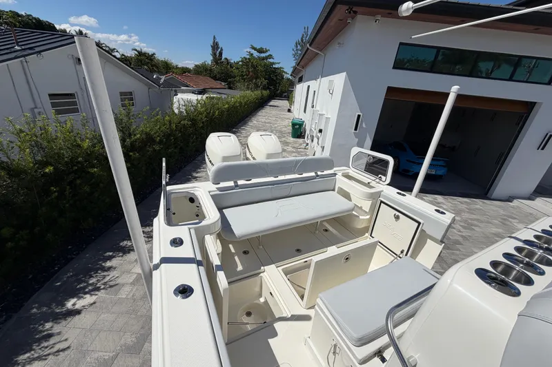 Slide: The Image of 2021 SeaVee 322Z boat docked near modern house, showcasing spacious deck and seating. - 9