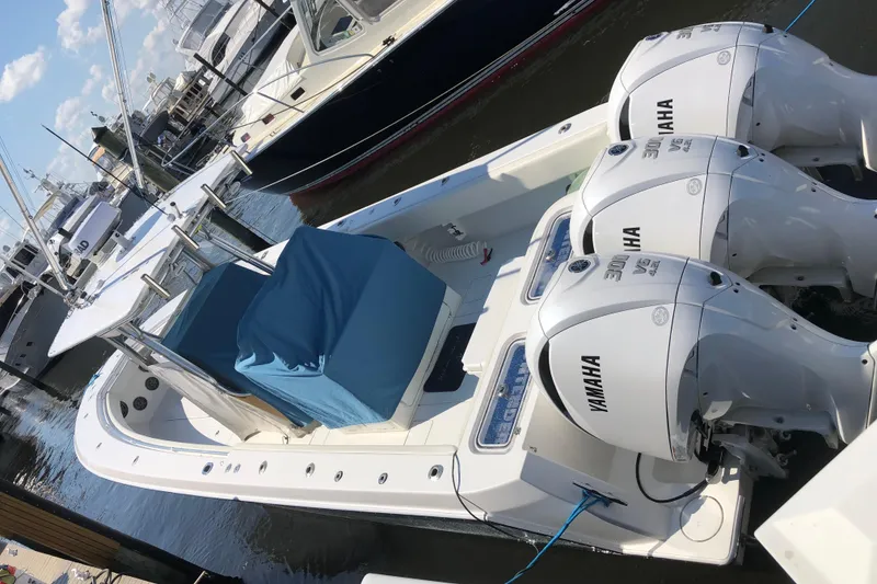 The Image of 2009 Contender 33 Tournament boat with triple Yamaha engines docked at marina. - 0