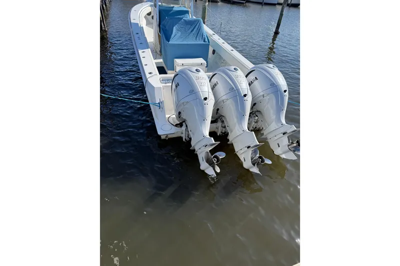 Slide: The Image of 2009 Contender 33 Tournament boat with triple Yamaha outboard engines docked in water. - 10