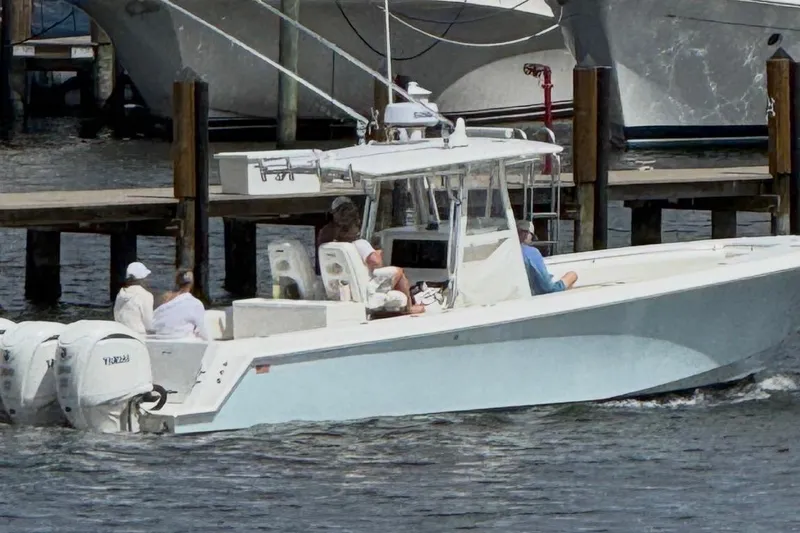 Slide: The Image of 2009 Contender 33 Tournament boat with passengers, docked near wooden piers. - 12