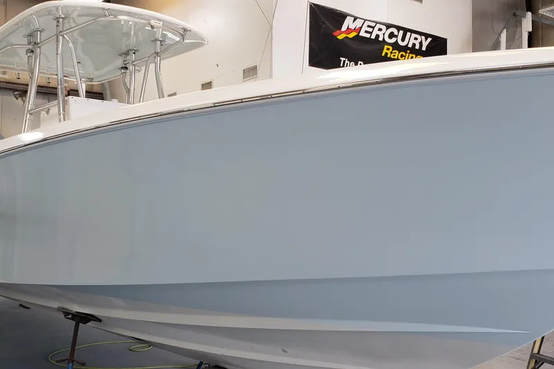 Slide: The Image of 2009 Contender 33 Tournament boat in showroom, featuring sleek design and Mercury Racing banner. - 15