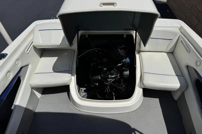 Slide: The Image of 2006 Bayliner 195 Bowrider engine compartment with open hatch and seating area. - 14