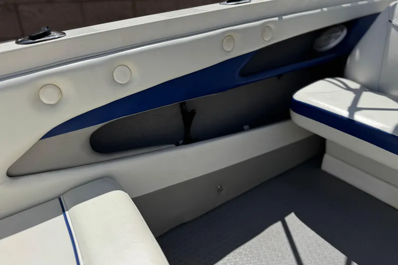 Slide: The Image of Interior of a 2006 Bayliner 195 Bowrider boat, featuring blue and white seating. - 25