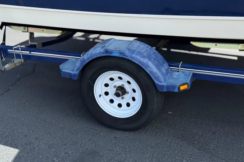 Slide: The Image of Trailer wheel of a 2006 Bayliner 195 Bowrider boat on pavement. - 26