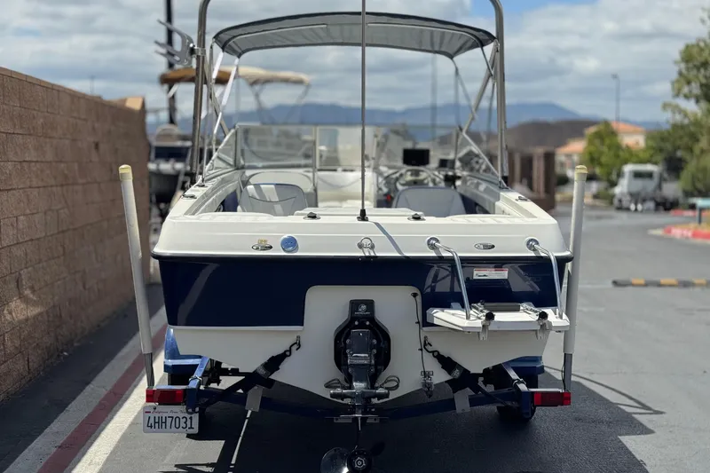 The Image of 2006 Bayliner 195 Bowrider boat with canopy, parked on a trailer. - 4