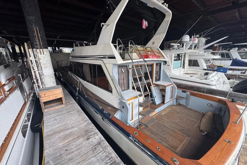 Slide: The Image of Docked 1990 Symbol 53 Sedan yacht with wooden deck and ladder in marina. - 3